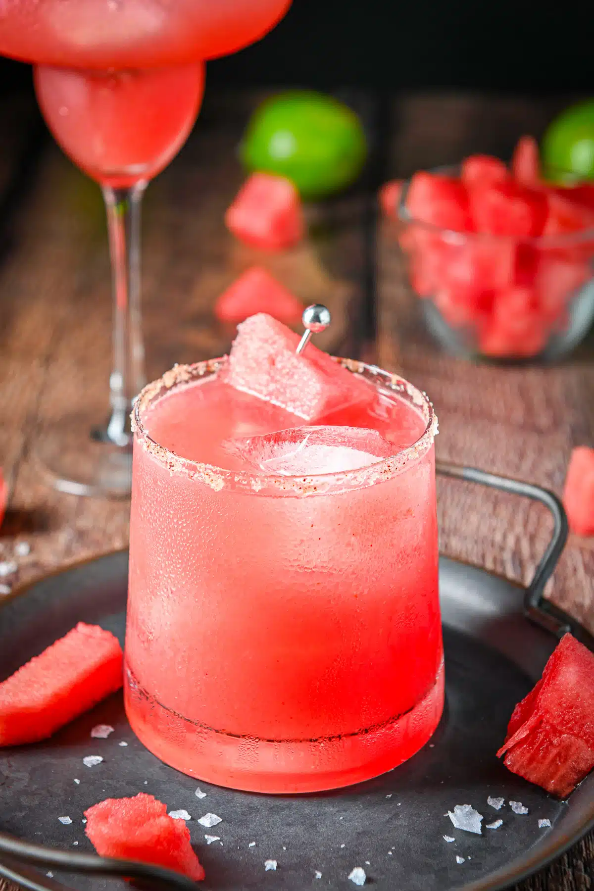 The short salted glass with the margarita in it with watermelon as garnish