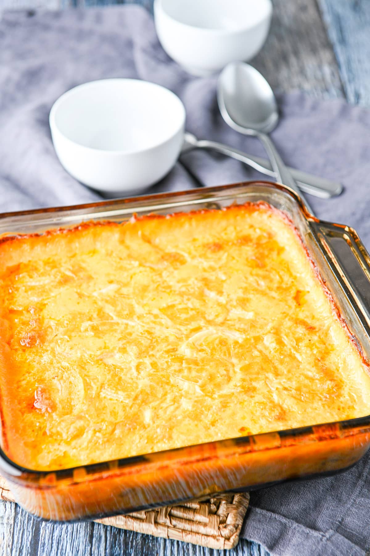 The potatoes out of the oven with two small white bowls in the back