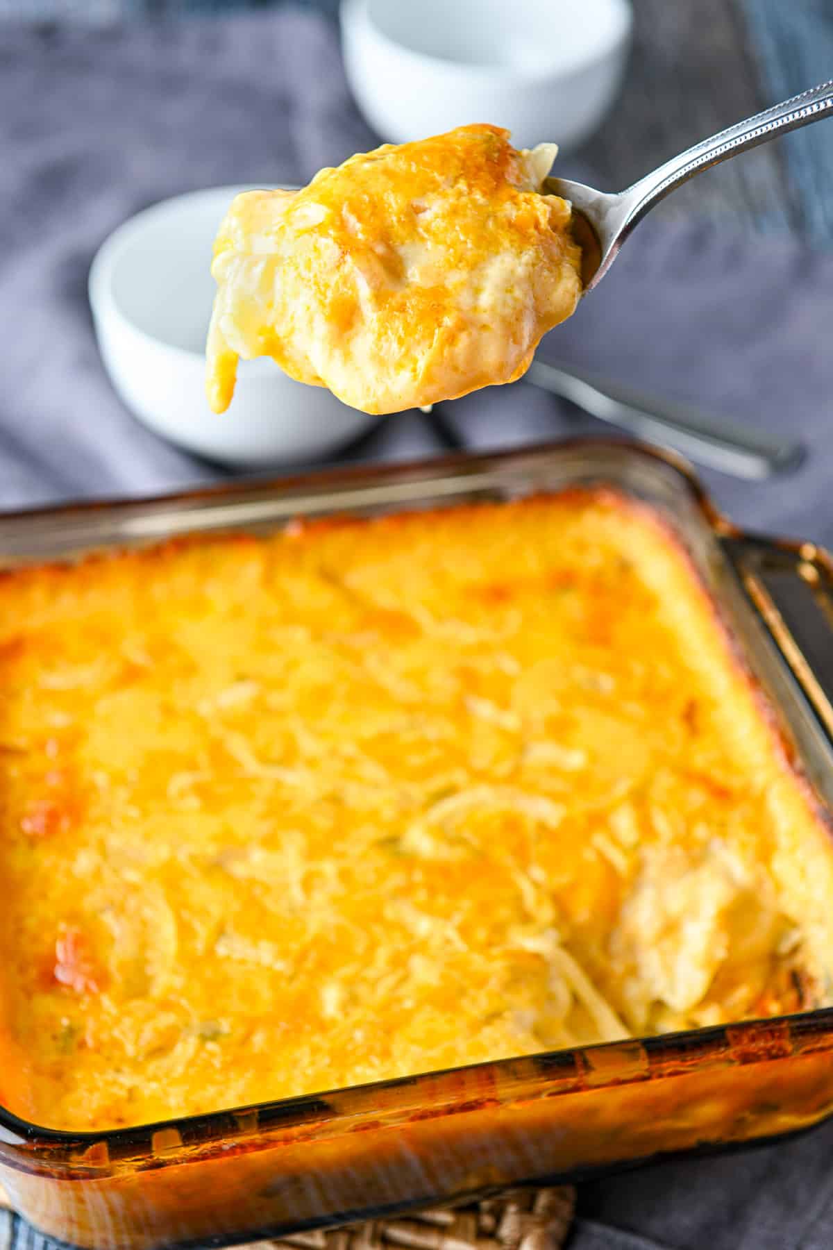 A fork with the potatoes on it held over the casserole dish
