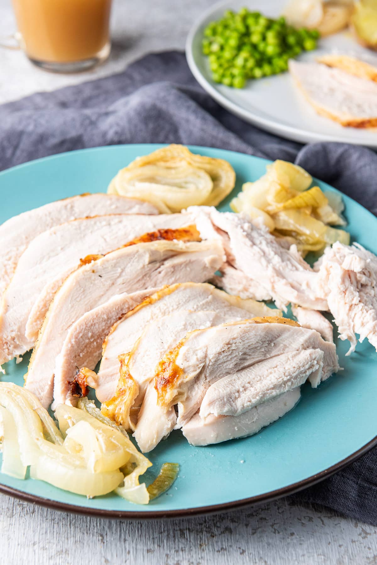 blue platter with sliced turkey on it with a plate behind