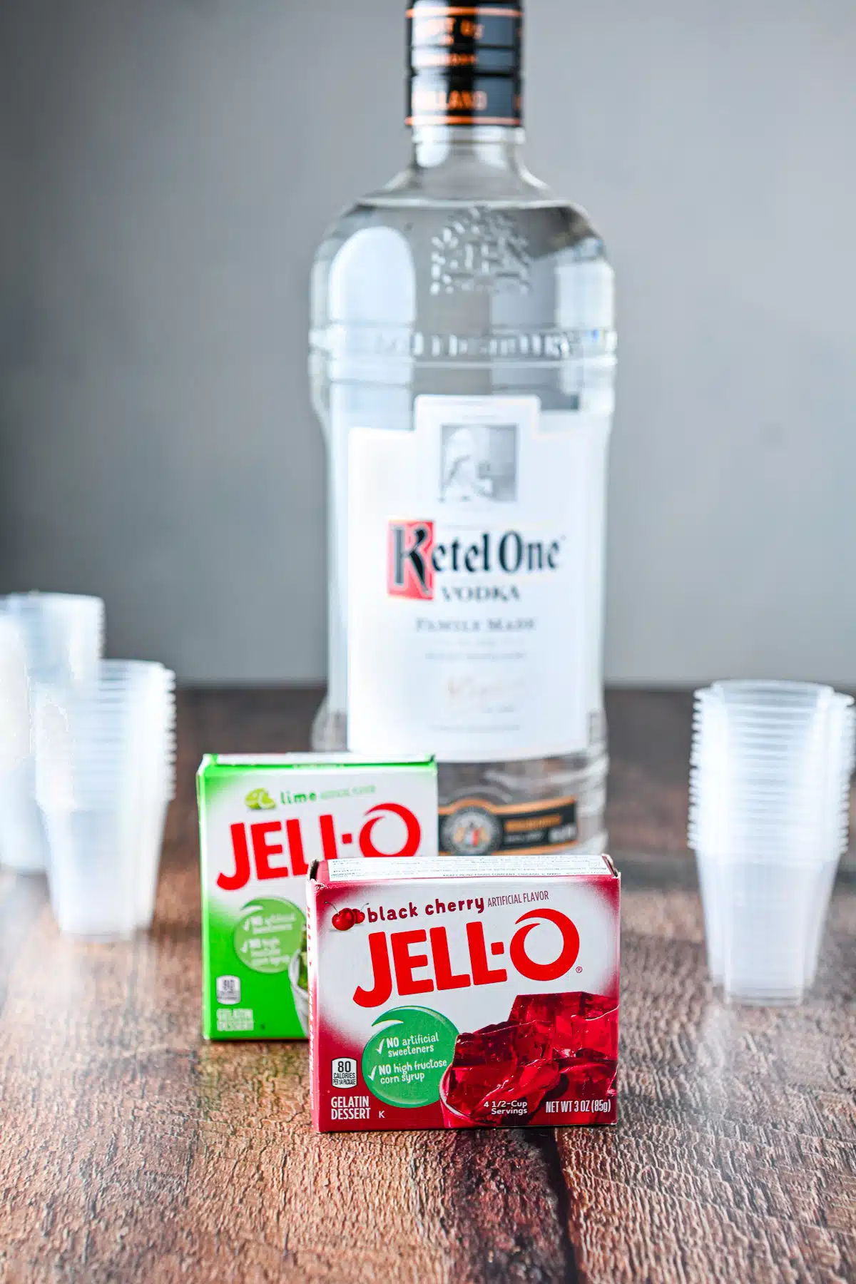 Red and green jello in the boxes with vodka and jello cups in back