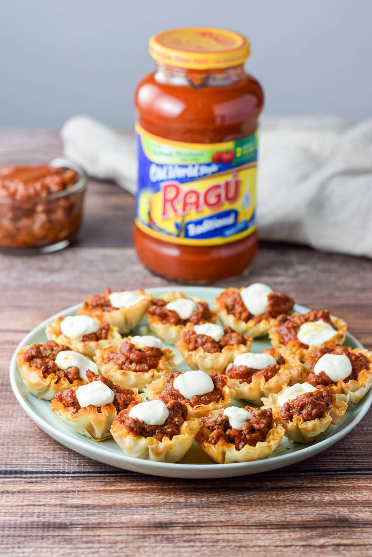 A plate of the appetizer with a bottle of red sauce in the background