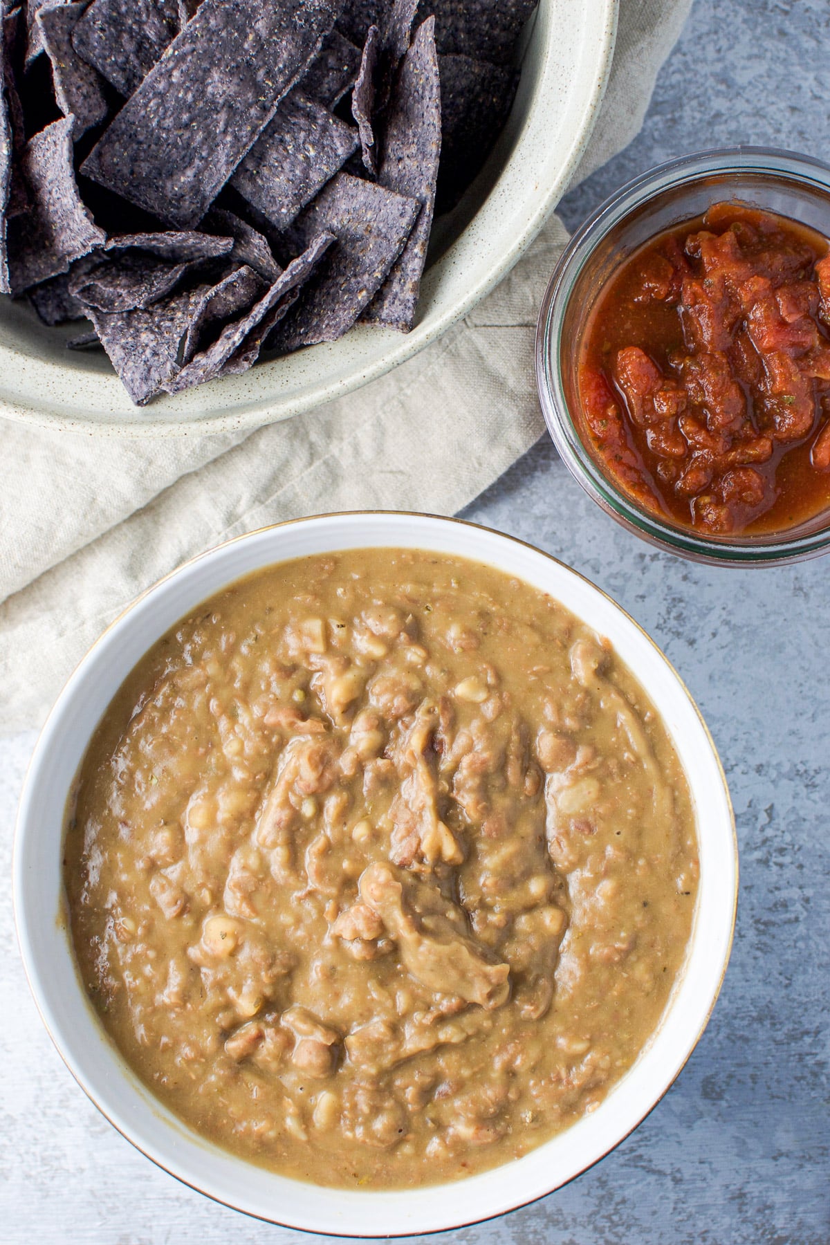 Overhead view of the bowl of refried beans, salsa and a bowl of chips