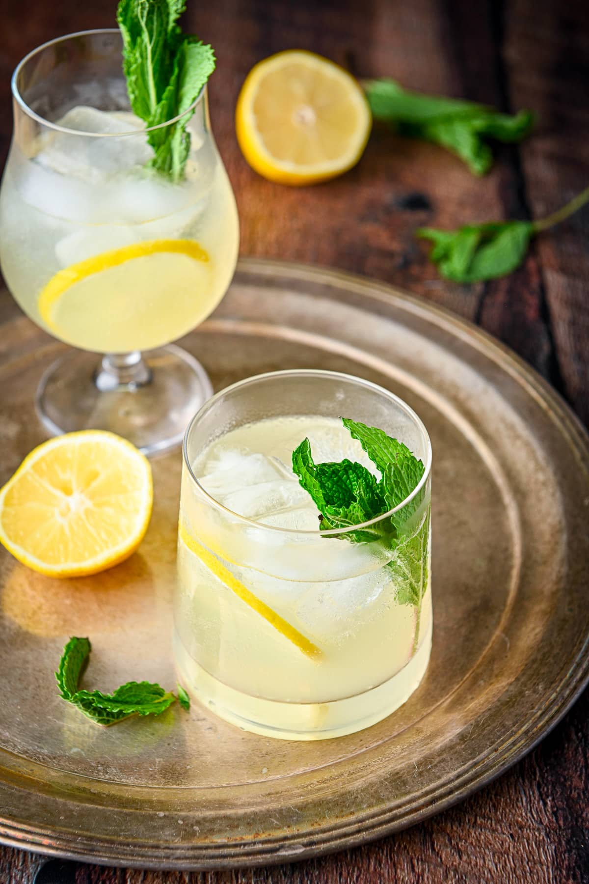 Mint and lemon slices garnishing the limoncello cocktails on the wooden table