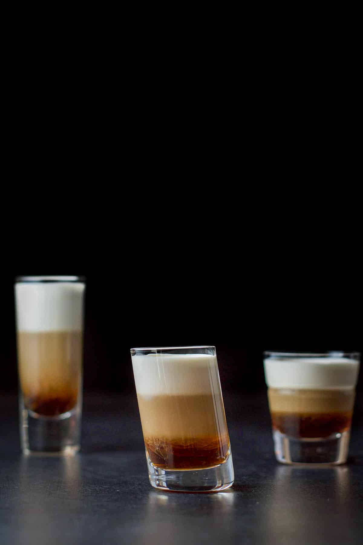 vertical view with the three shot glasses with the tilted glass in front