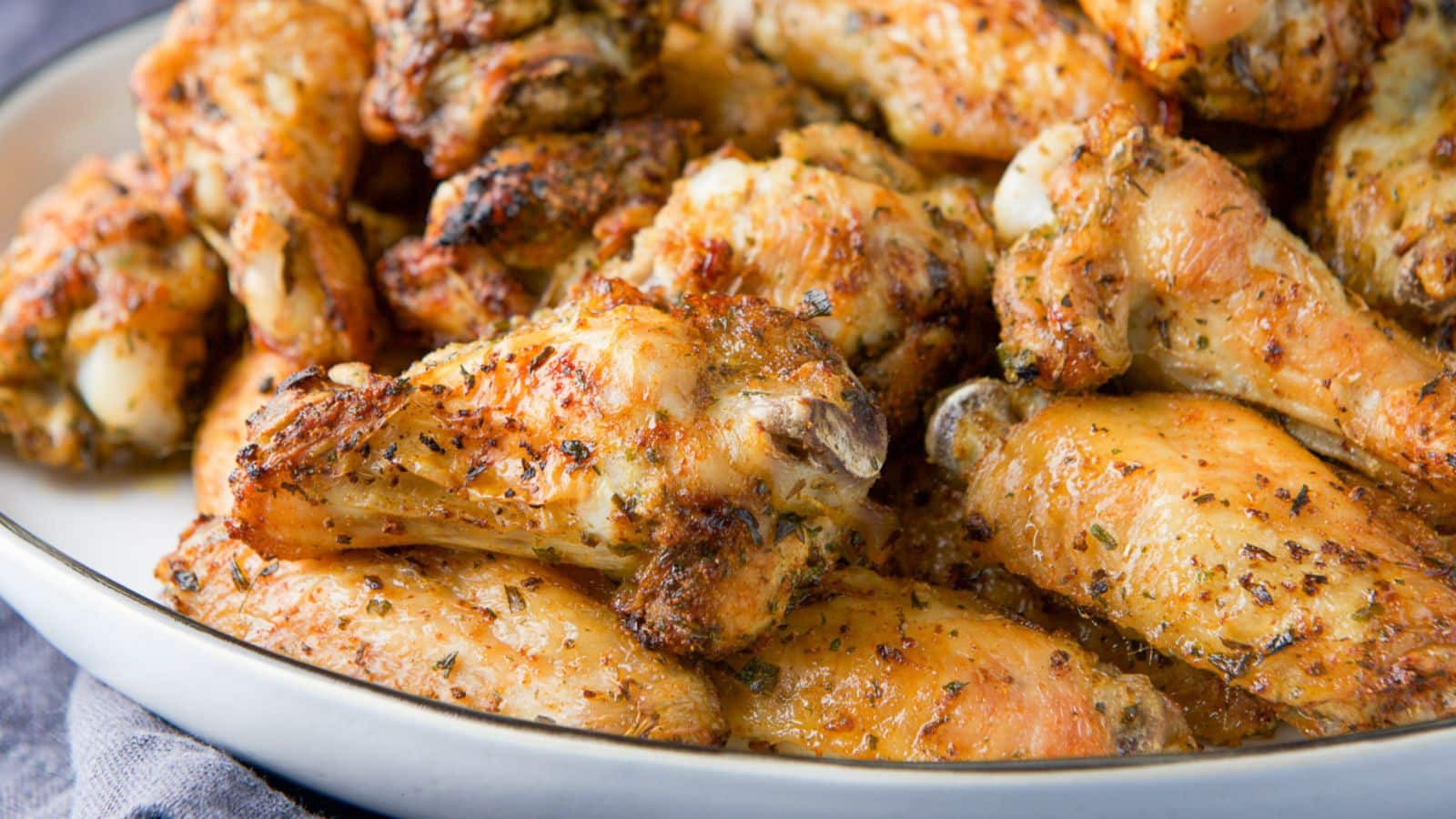 A white plate with crispy chicken wings on it