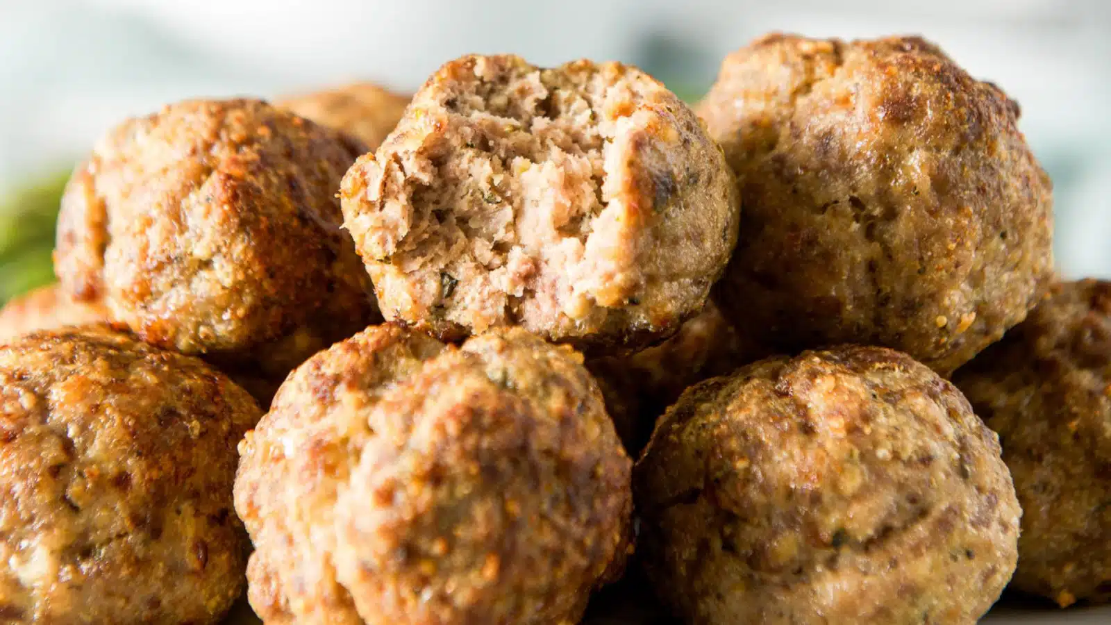 Closeup of meatballs stacked on each other with a bite taken out of one