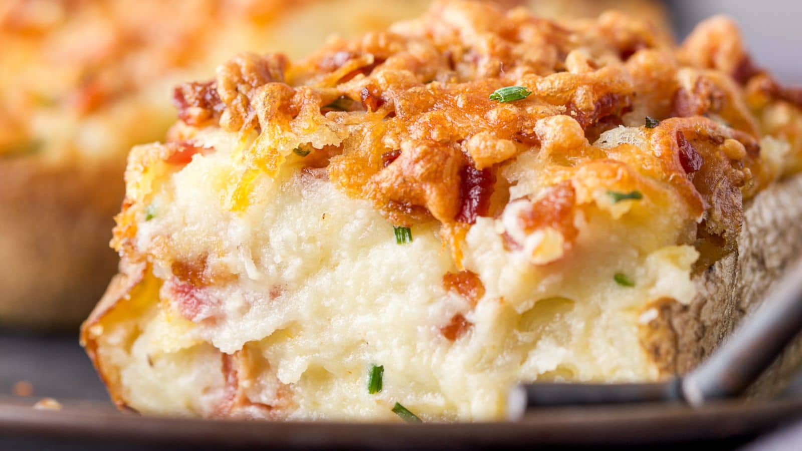 close up of a creamy potato with cheese melted on top