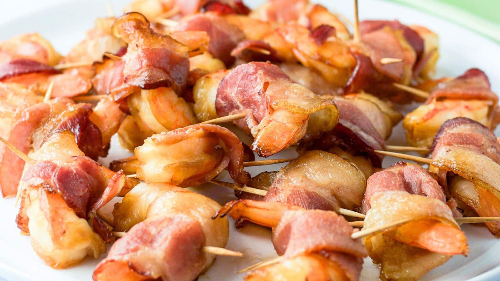 bacon and shrimp with toothpicks piled on a plate