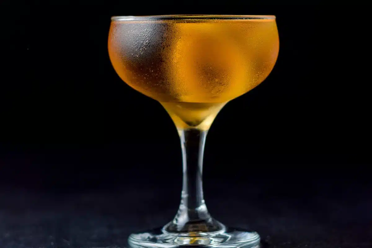 A coupe glass filled with a golden drink
