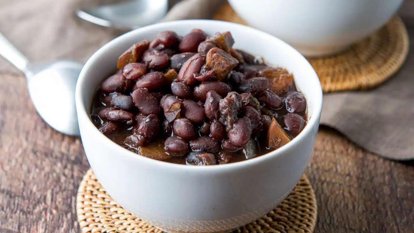 a small white bowl with black beans in it