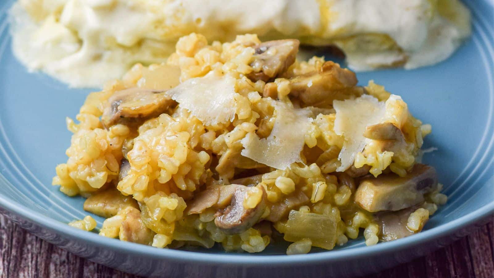 A blue plate with a rice and mushrooms along with an enchilada
