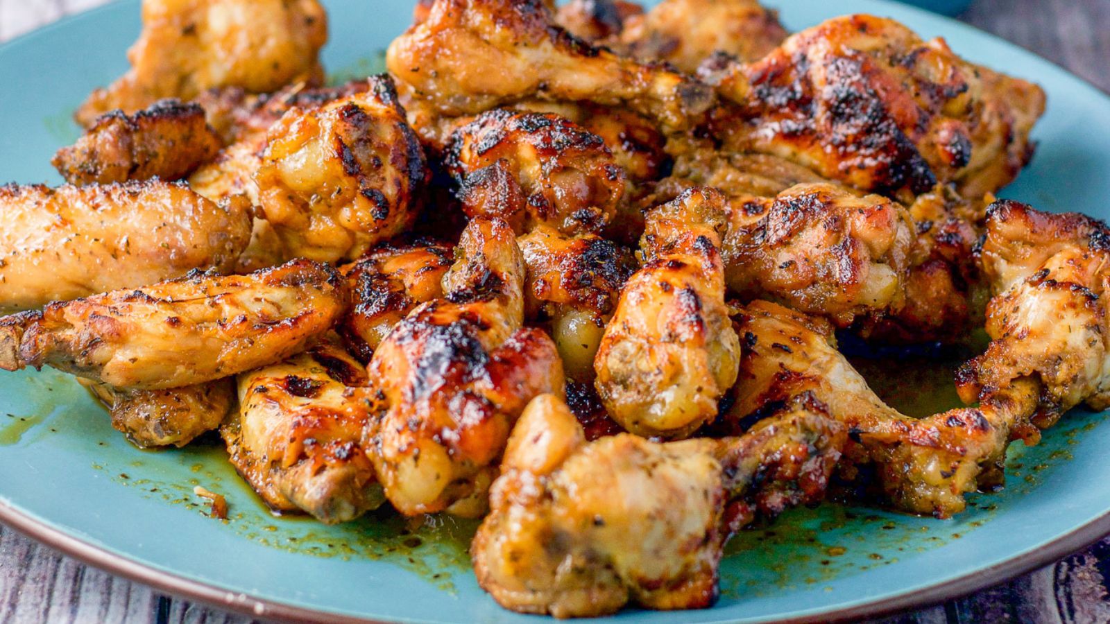 A blue platter with chicken wings piled up