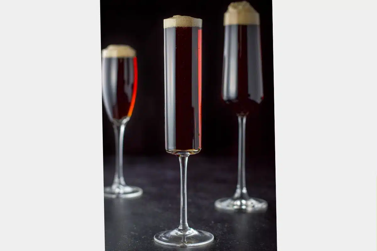 three champagne glasses filled with the red velvet cocktail