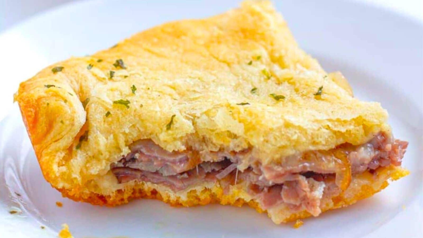 a white plate with a slice of flakey slider with a bite taken out of it