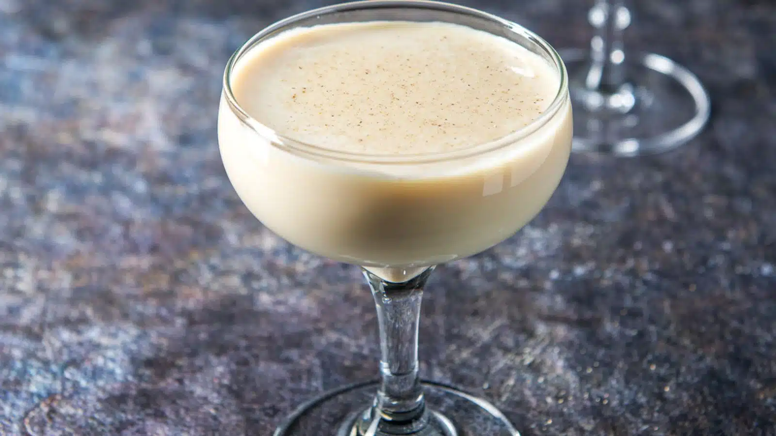 a coupe glass filled with the cream drink with nutmeg sprinkled on top