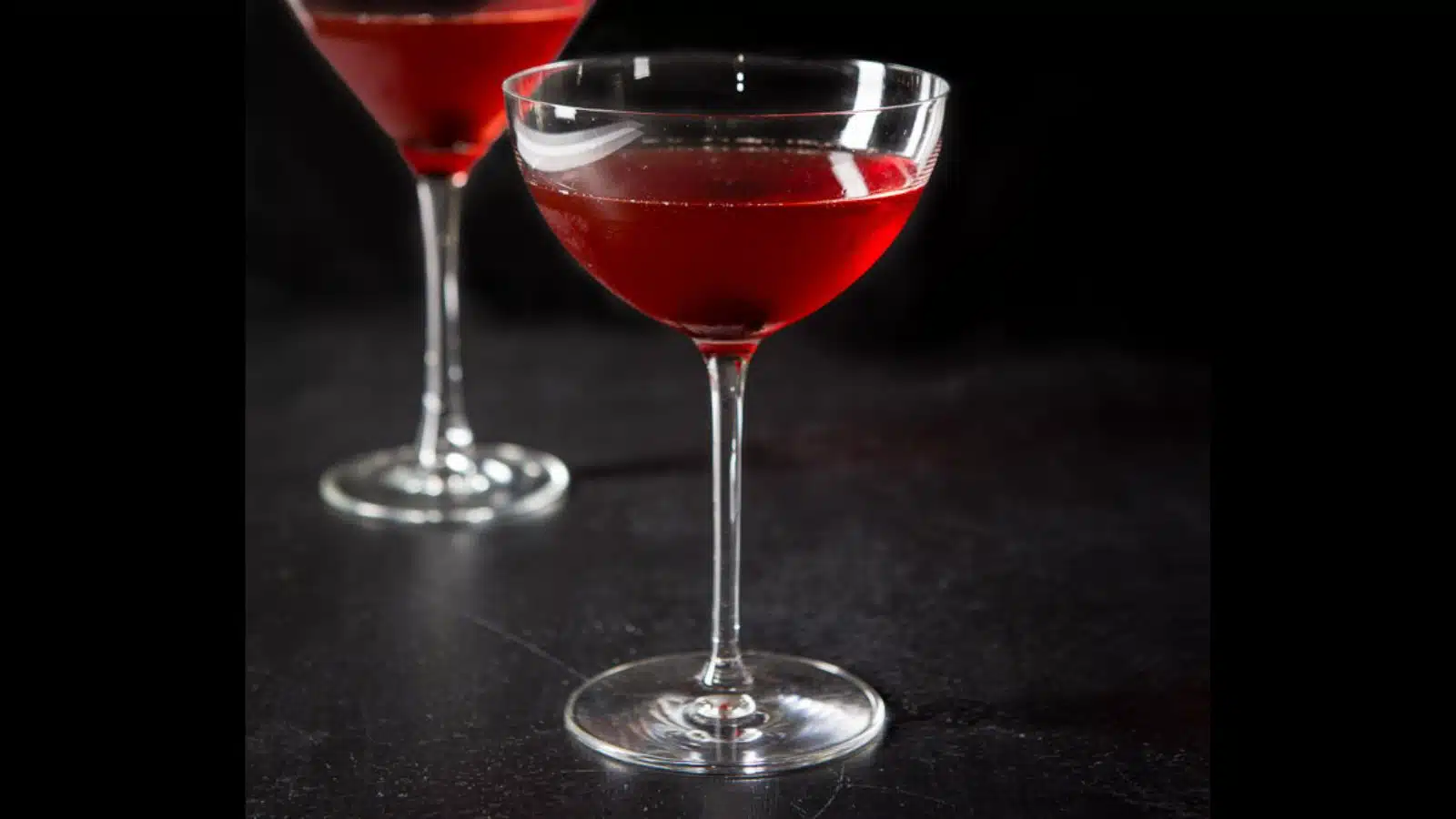 Two martini glasses filled with the Manhattan with a cherry in the glass