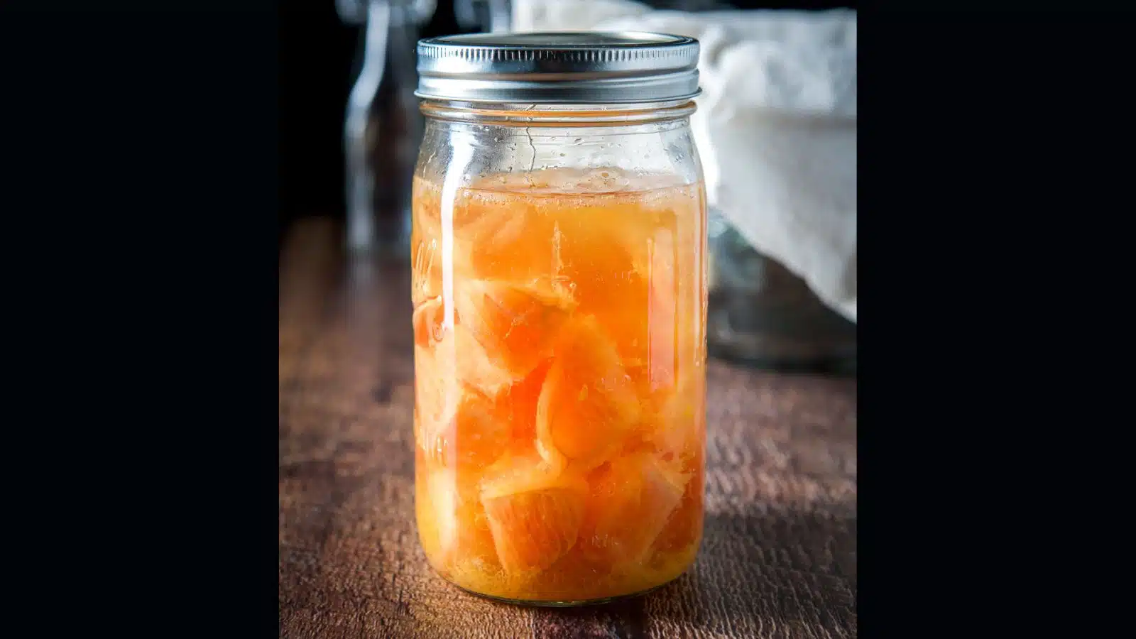 A jar with vodka and chunks of grapefruit