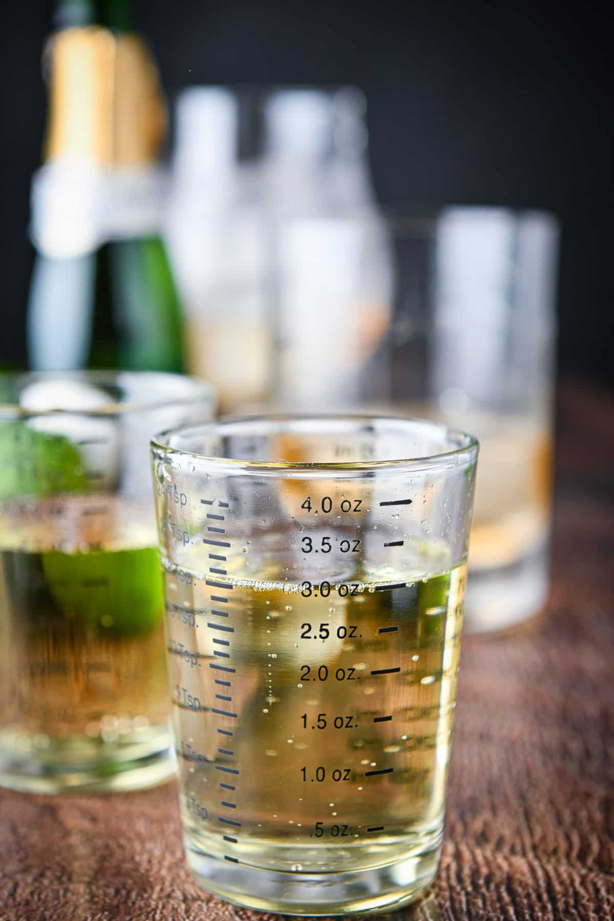 Prosecco measured out with the bottle and glasses in the back