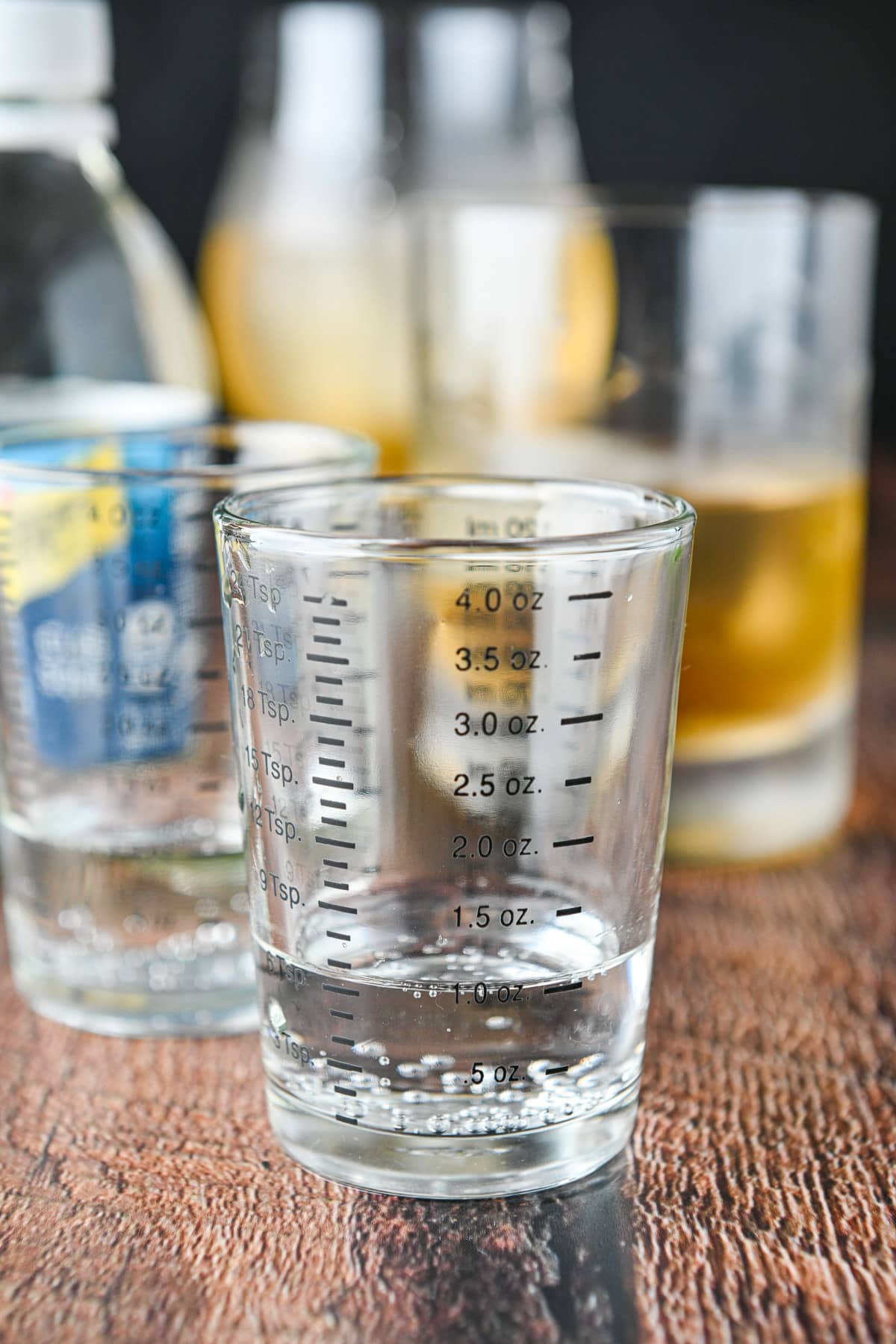 Club soda measured out with the bottle and glasses in the back