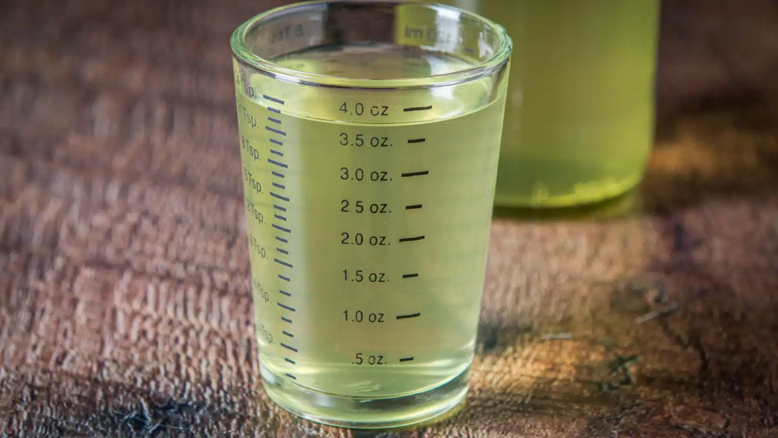 A four-ounce measuring glass with lemon vodka
