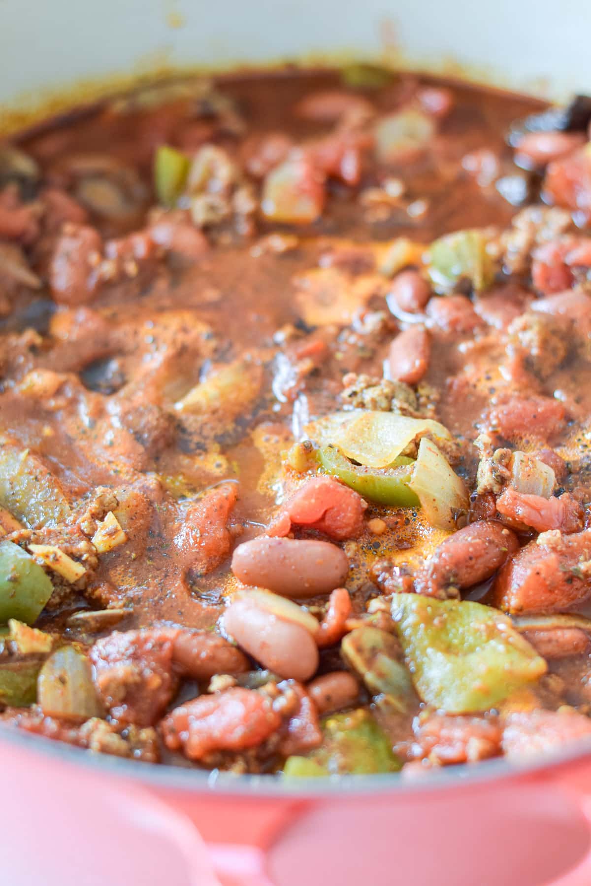 a red pot with the chili in it with veggies and beans