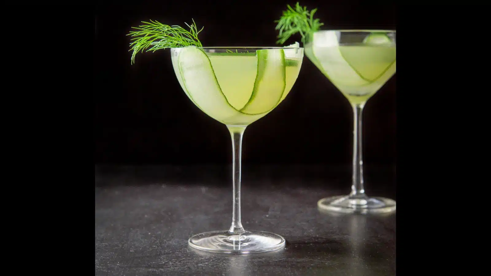 Two glasses with cucumber slices and dill in the lime drink