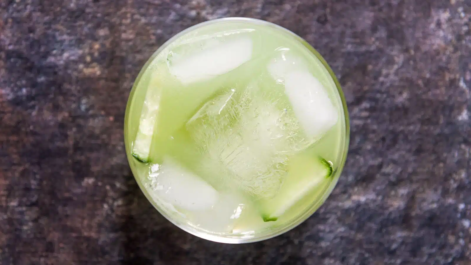 overhead view of the cucumber drink with ice cubes in it and slices of cucumber