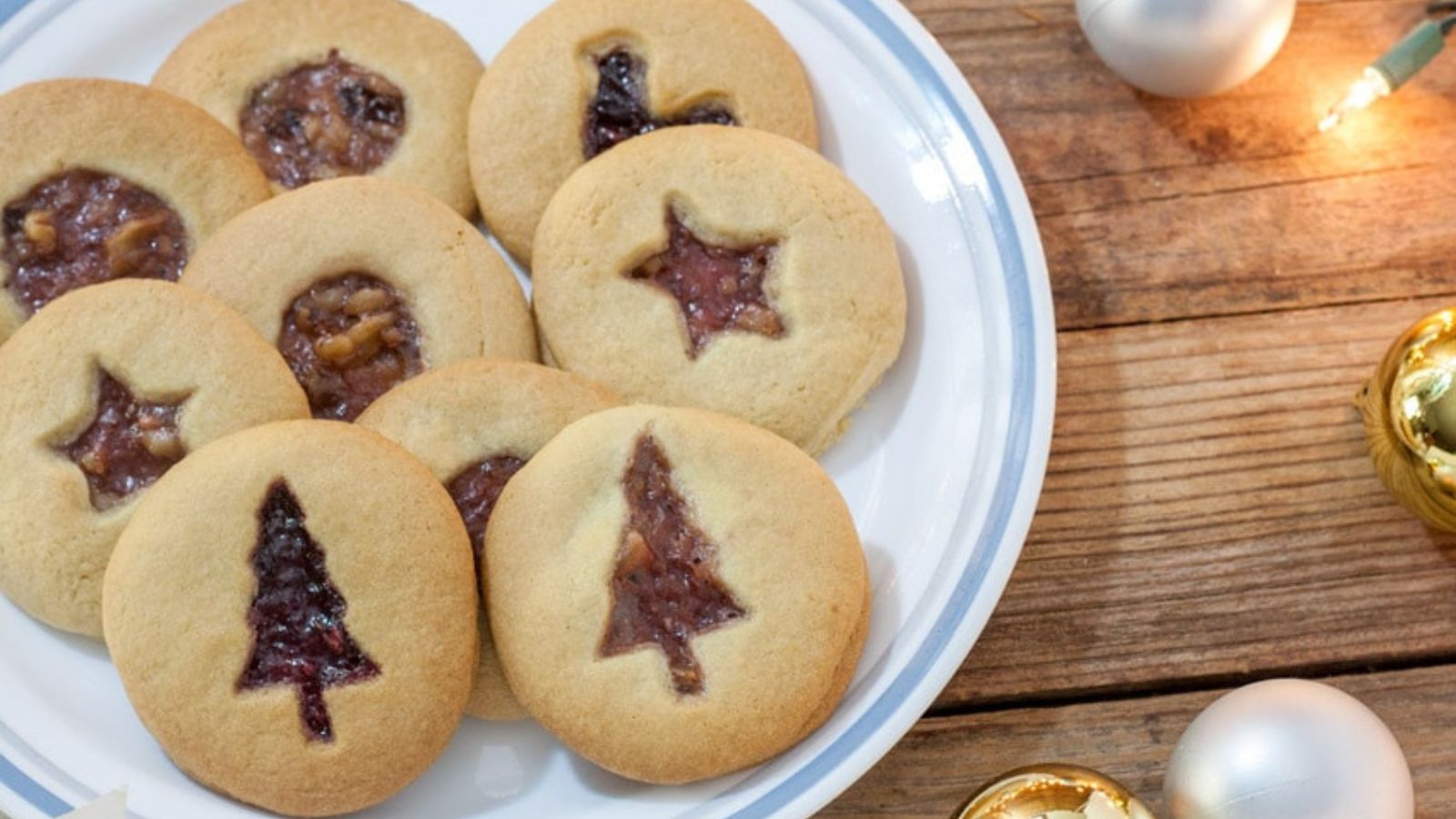 a plate with nine fruit filled cutout cookies on it