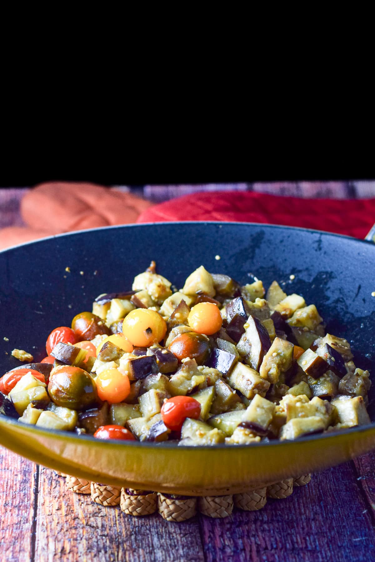 Cooked tomatoes and eggplant on the polenta with a salad and pan of polenta in the background