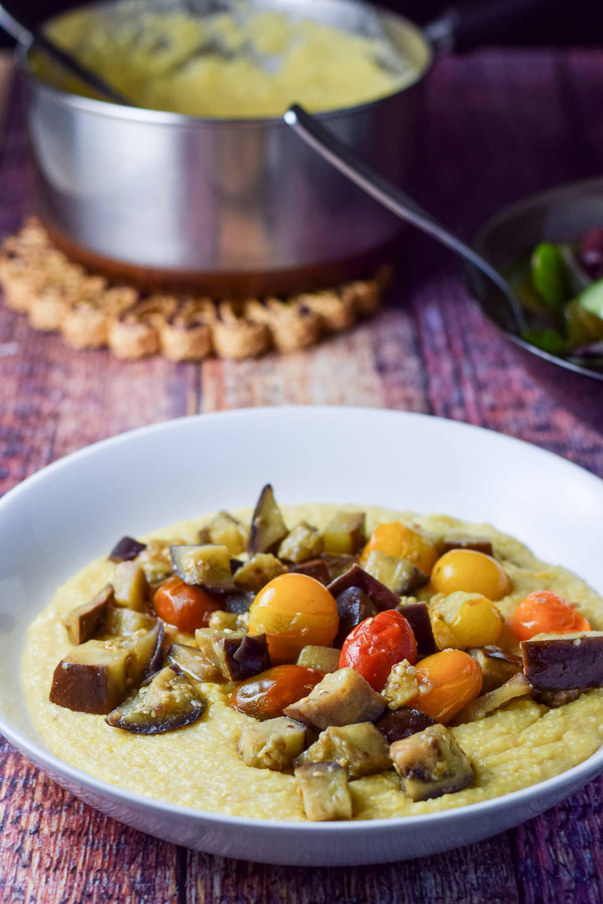 Close up of the eggplant and tomatoes on polenta with the pan in the background