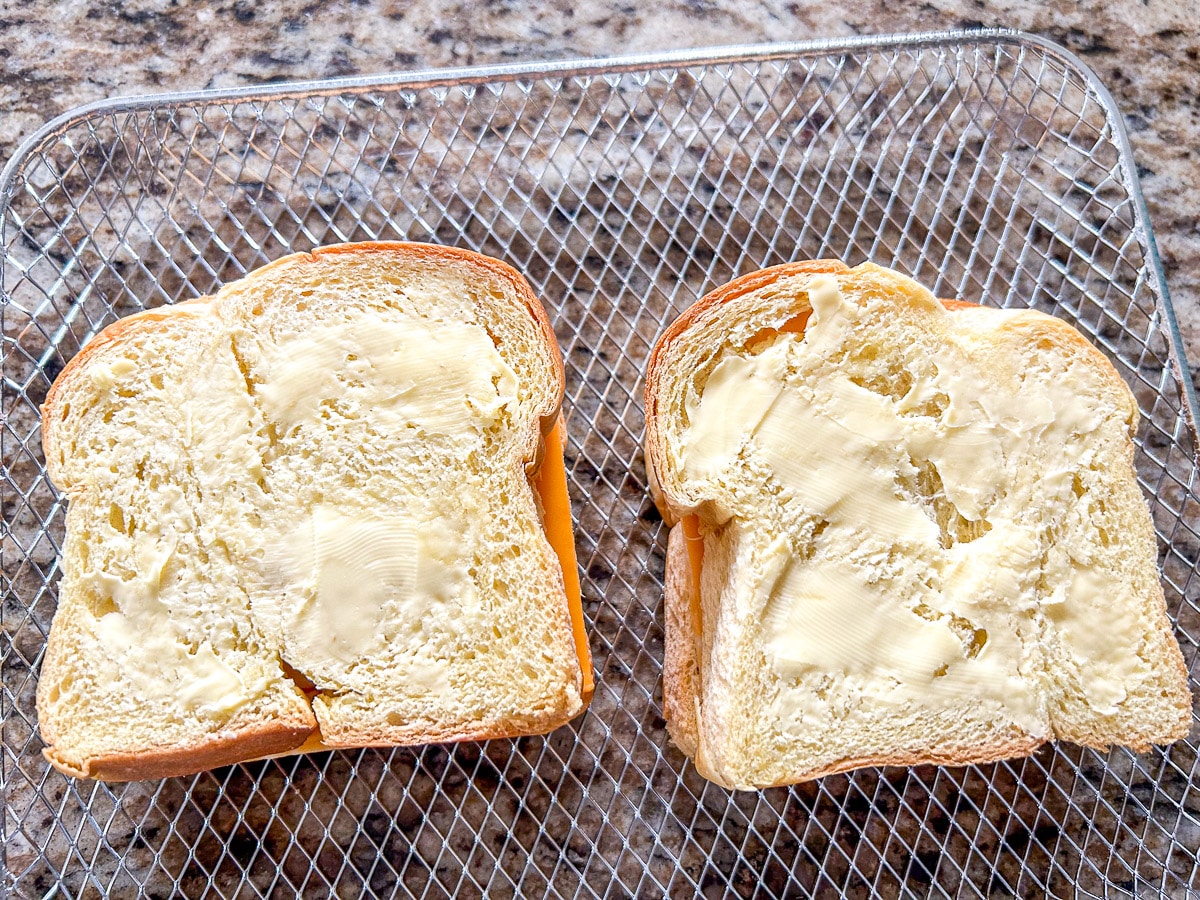 Butter on the bread with cheese in it - all on a wire rack