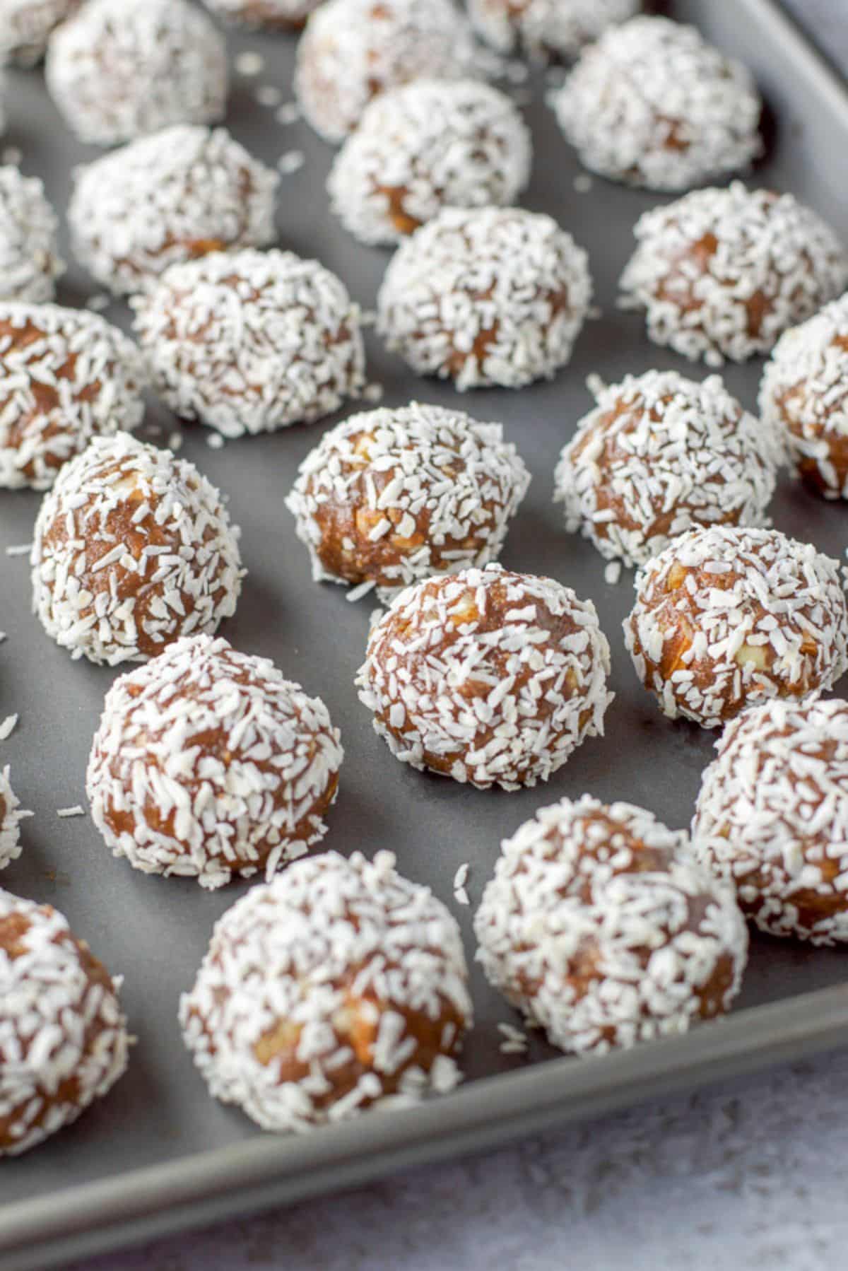 A pan with the coconut covered balls on it