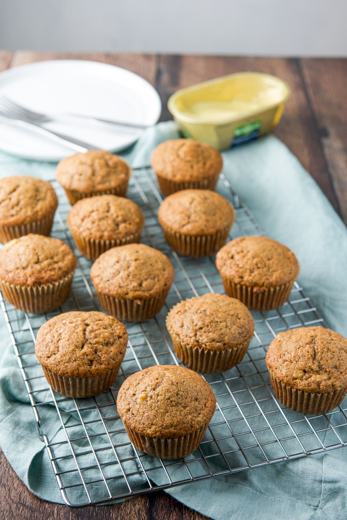 muffins on a wire rack cooling with butter in the back and plates