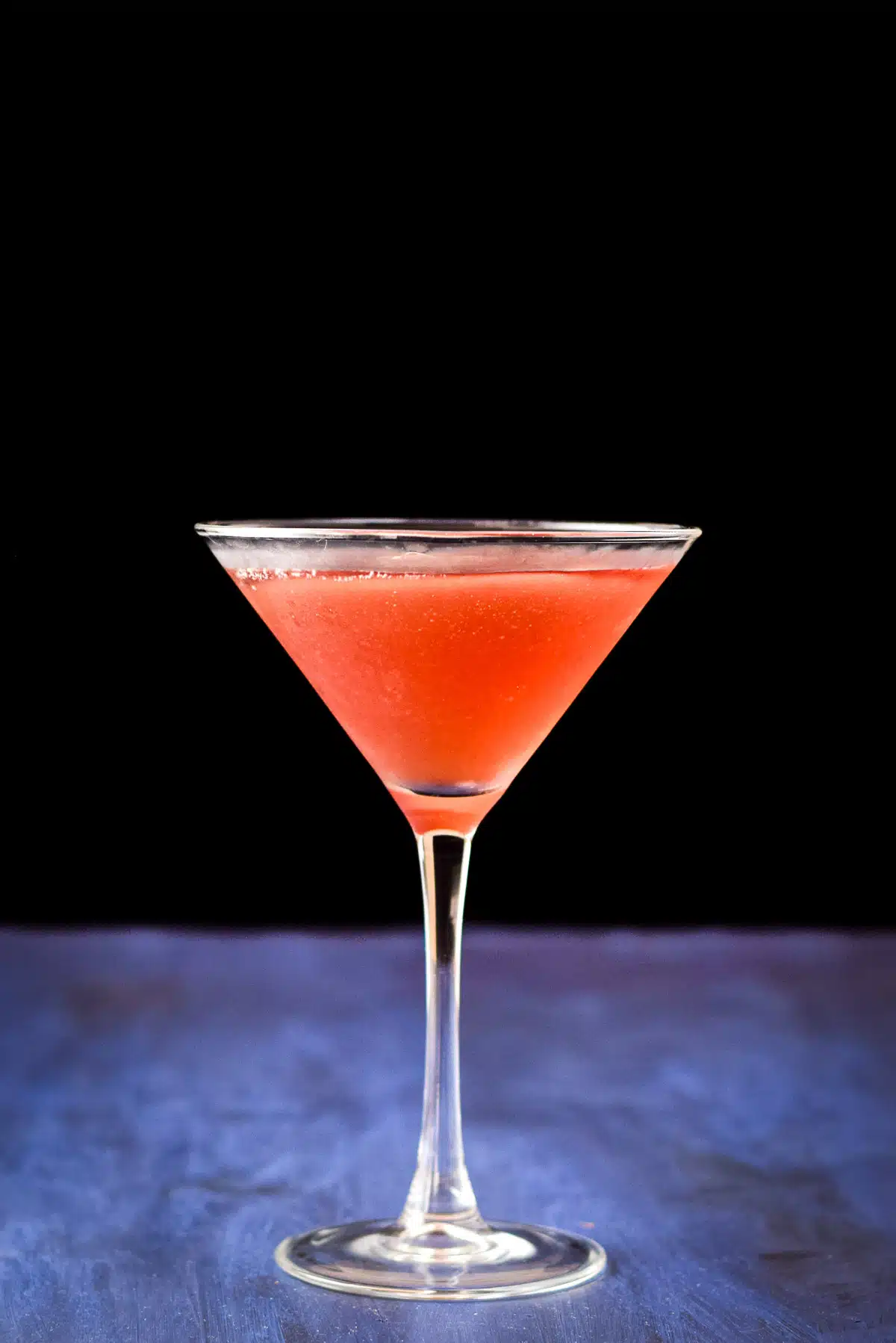 Vertical view of a martini glass filled with a red drink