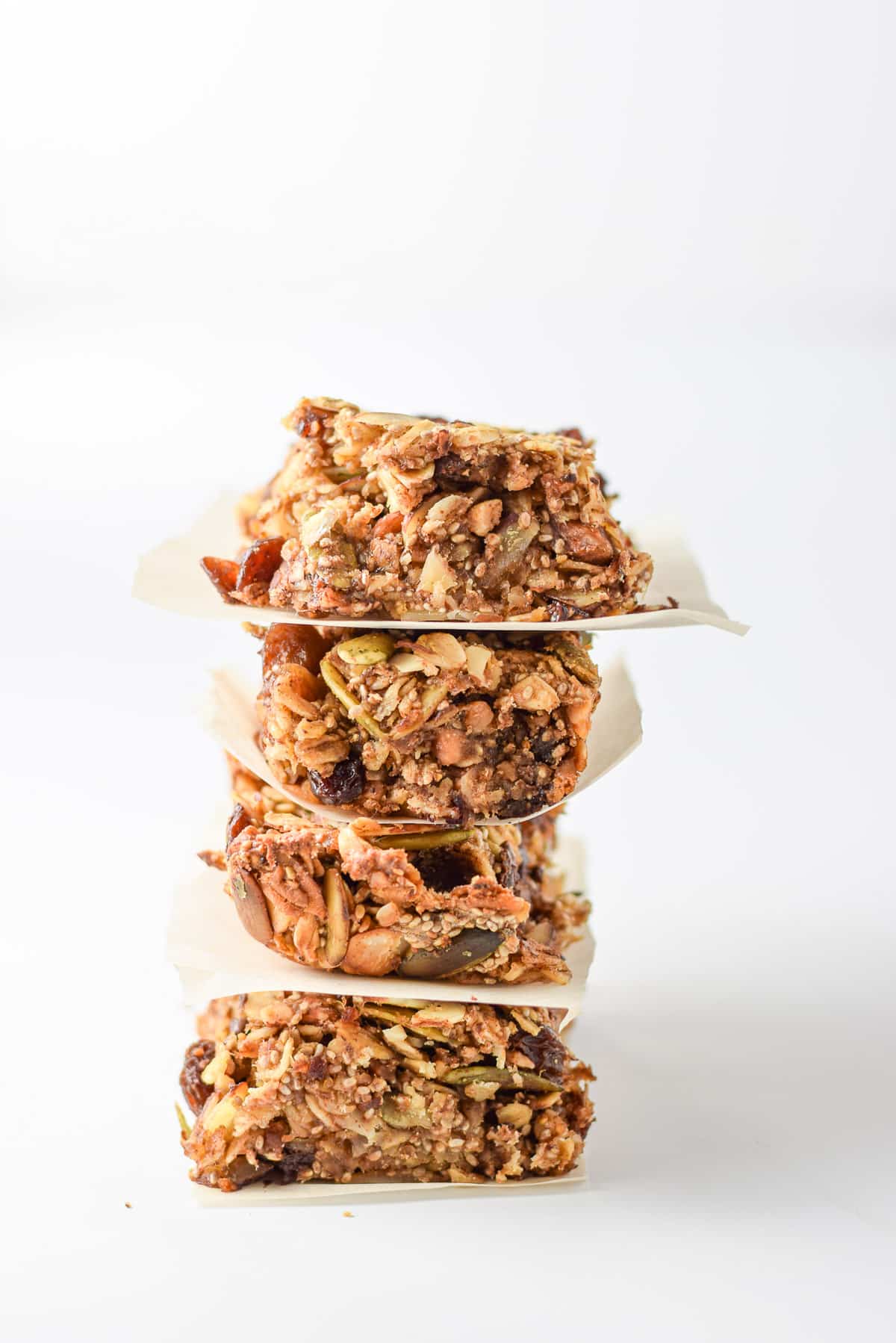 A stack of four granola bars tilting to the right with a white background