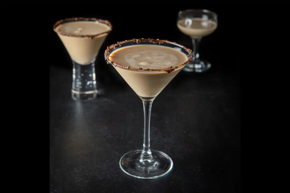 three martini glasses filled with the chocolate martini with chocolate on the rims