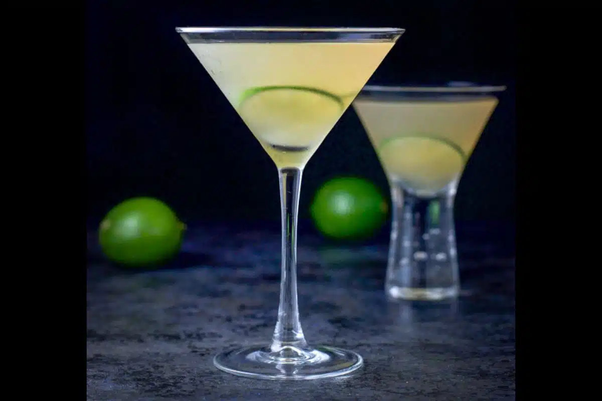 two martini glasses filled with the daiquiri with limes as garnish