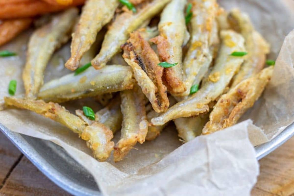 Fried smelts on wax paper on a tray