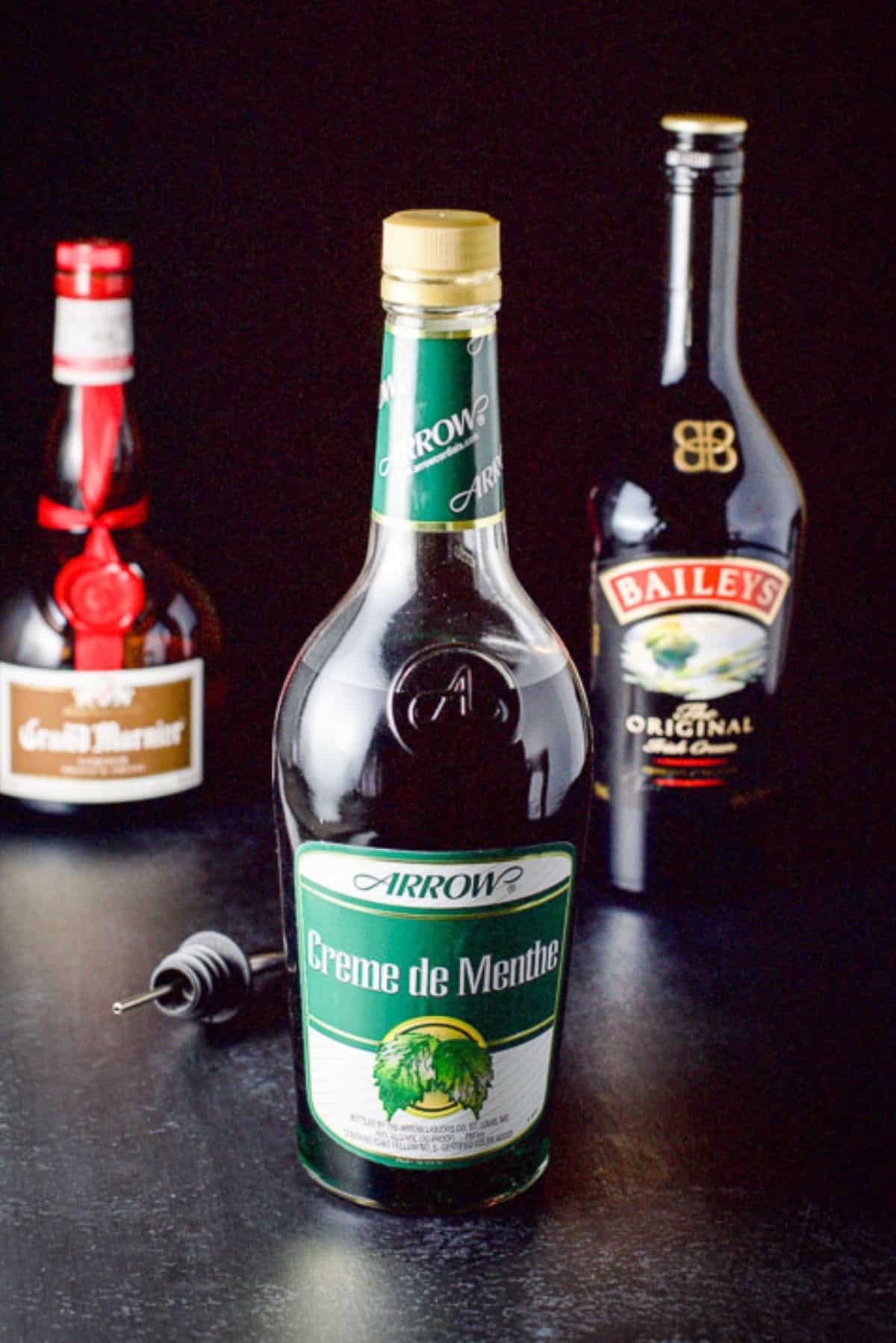 Creme de Menthe, Baileys Irish cream and Grand Marnier on a table