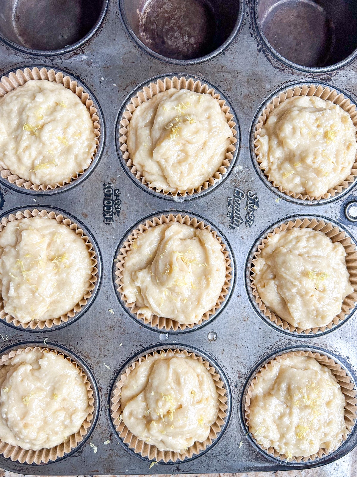 overhead view of a muffin pan with the muffin batter in it