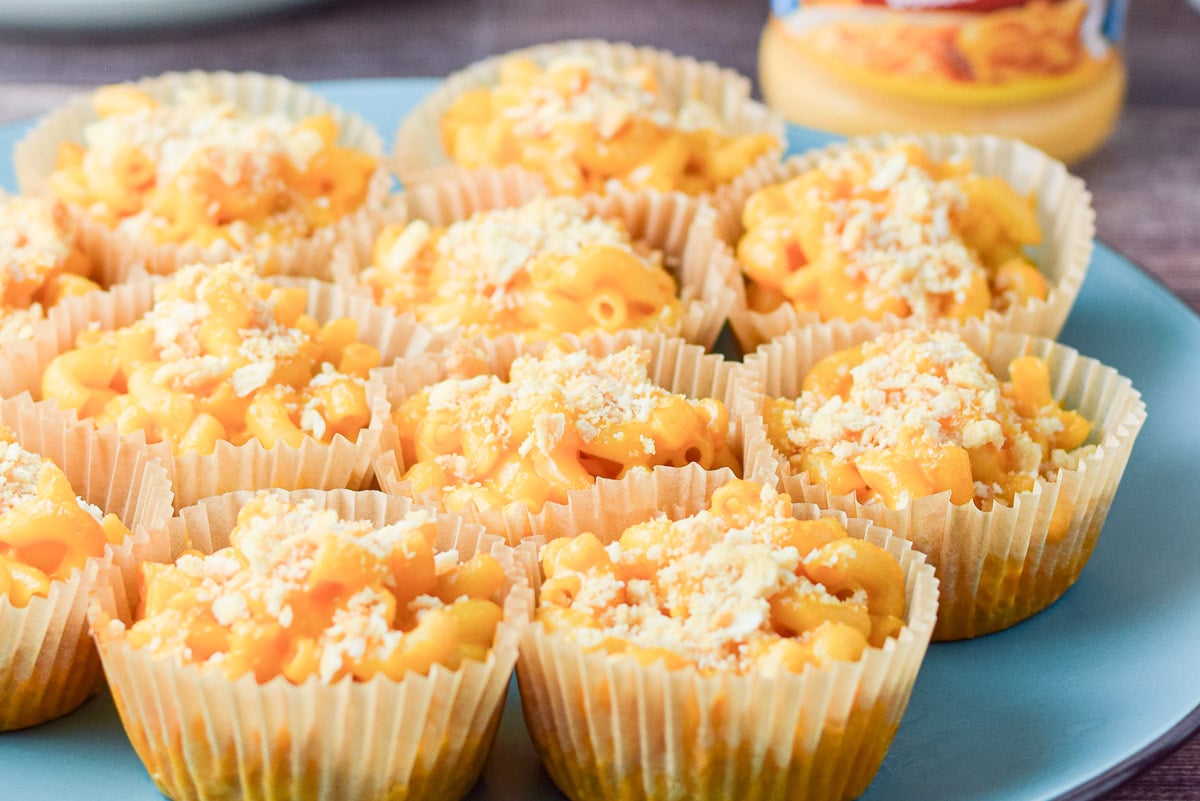 Blue plate with muffin cups of mac and cheese in them