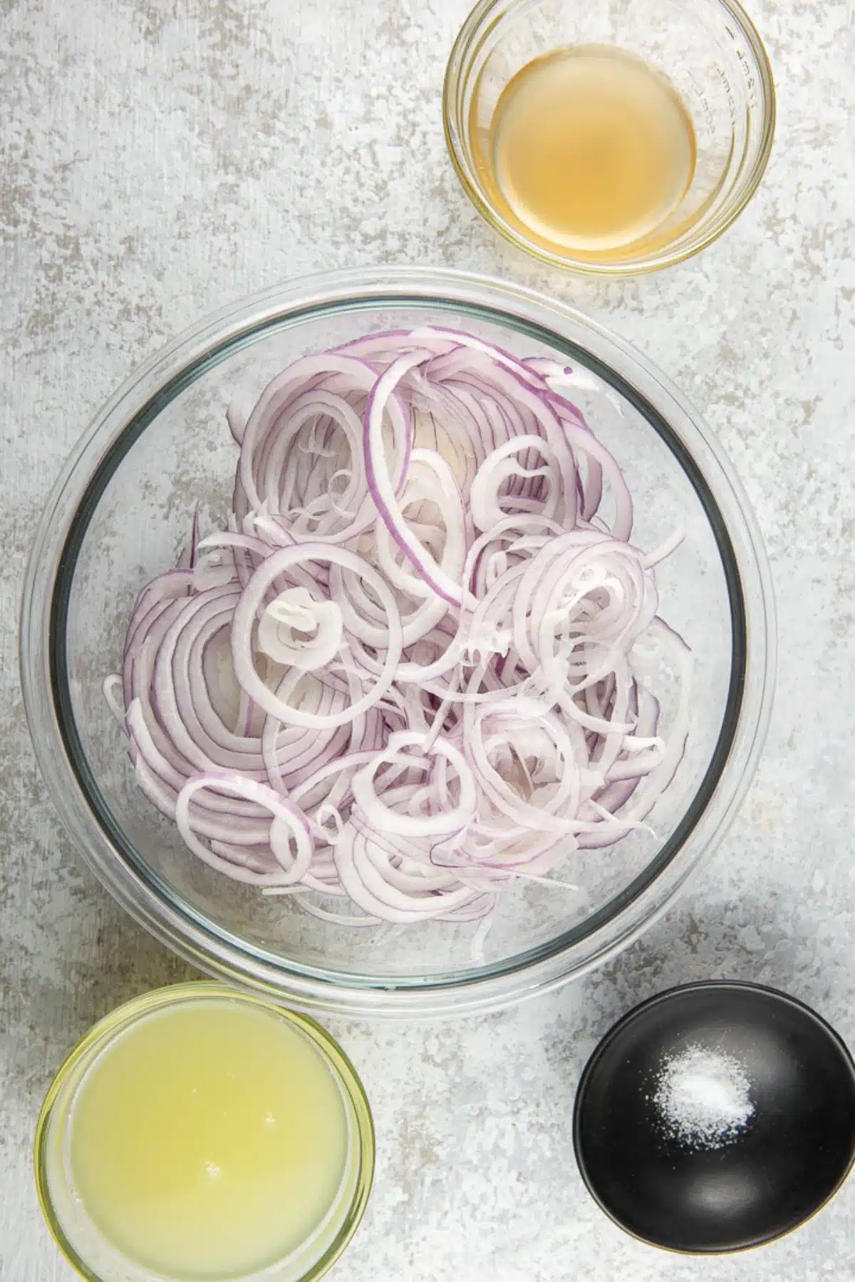 overhead view of the sliced onions with lime juice, apple cider vinegar, and salt