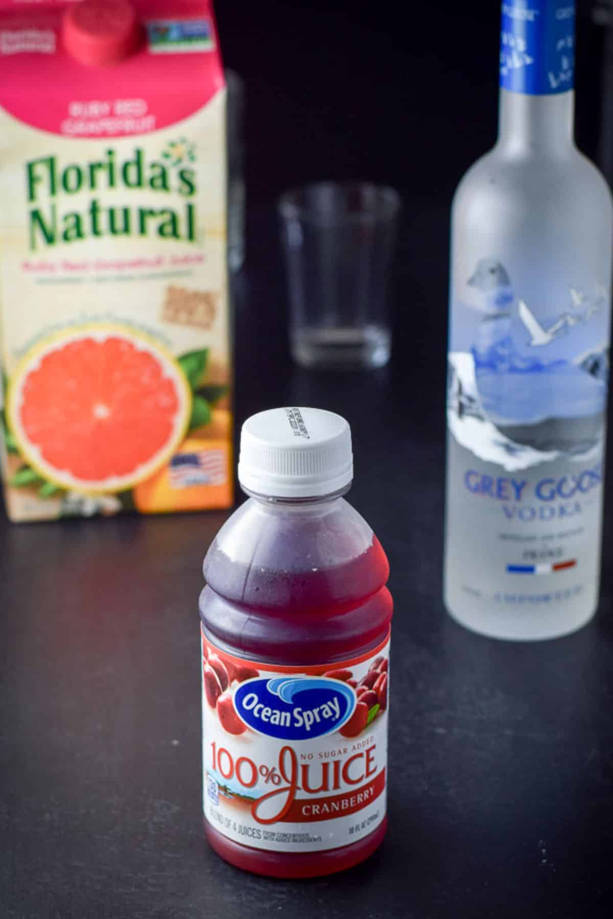 Cranberry juice, vodka and grapefruit juice with a measuring glass in the background