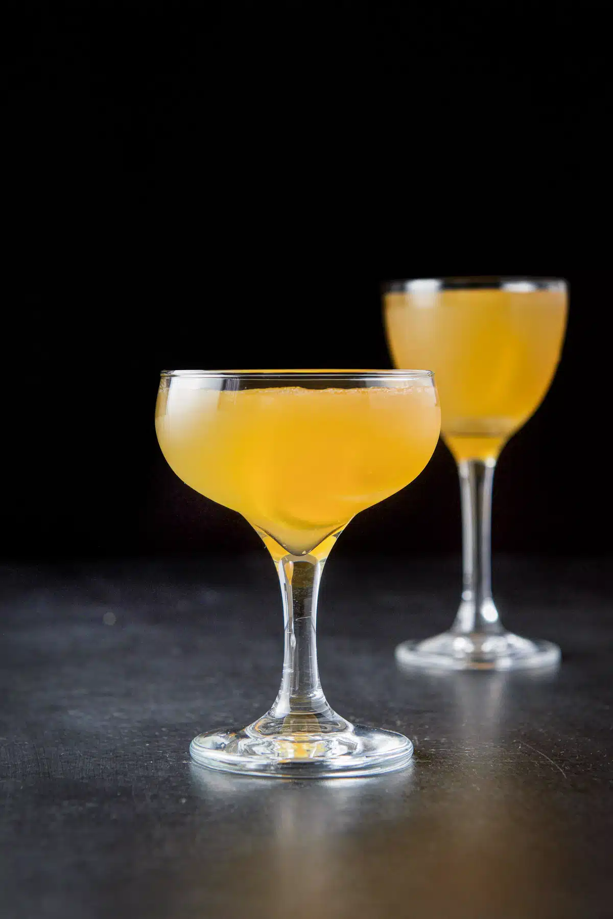 vertical view of the glasses with the amber liquid with lemon twists