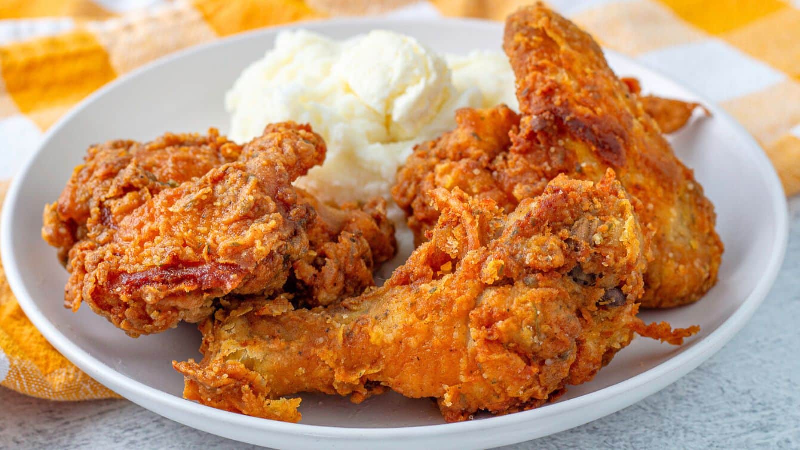 a plate with pieces of fried chicken and potatoes on it