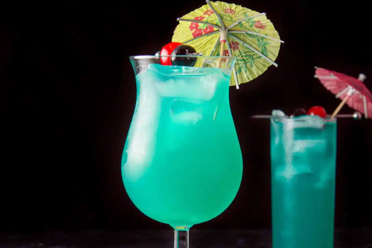 Vertical view of the tulip glass filled with the pretty blue drink with the garnish