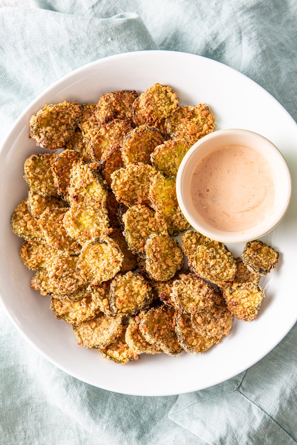 Overhead view of the pickles on a plate with dip