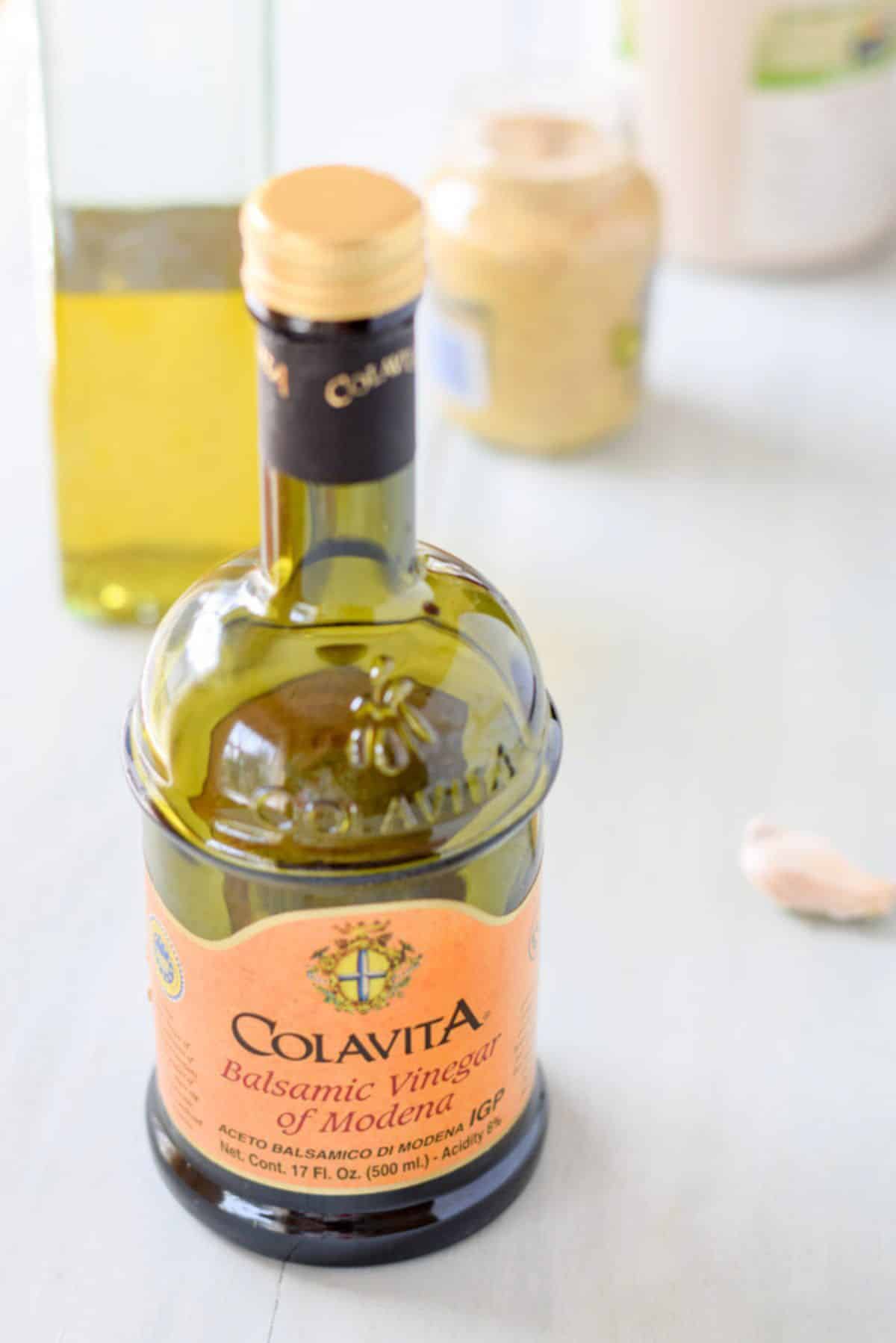 Balsamic vinegar, olive oil, mustard, garlic and maple syrup on a table