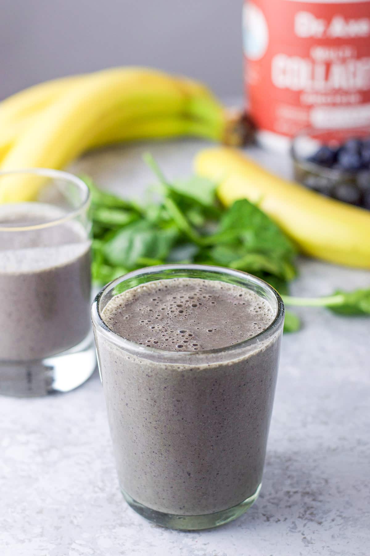 Close up of the glasses with the smoothie with bananas, blueberries and collagen in the background